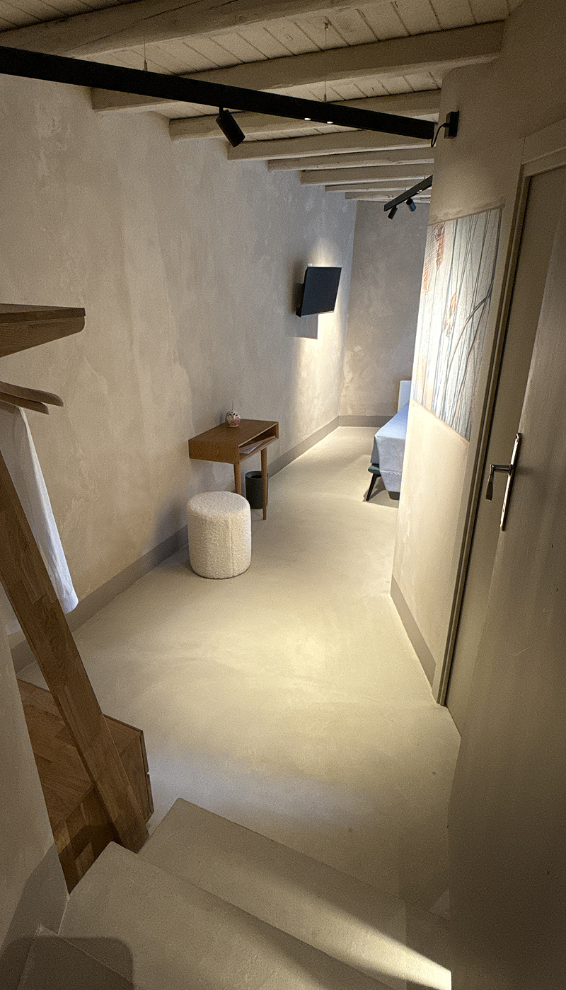 Lo spazio d’ingresso con illuminazione puntuale e scorcio su camera da letto e angolo scrittoio.