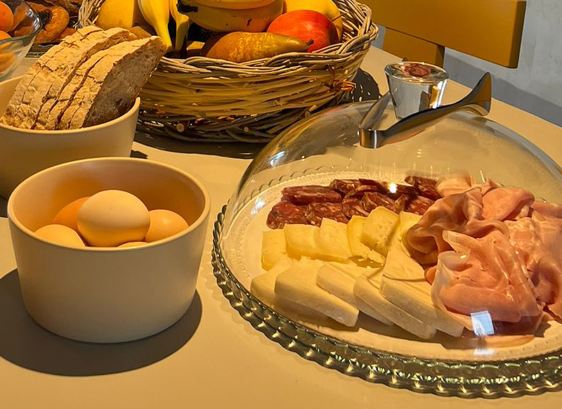 Tagliere con affettati e formaggi locali, pane rustico, uova e frutta in un B&B in Ciociaria