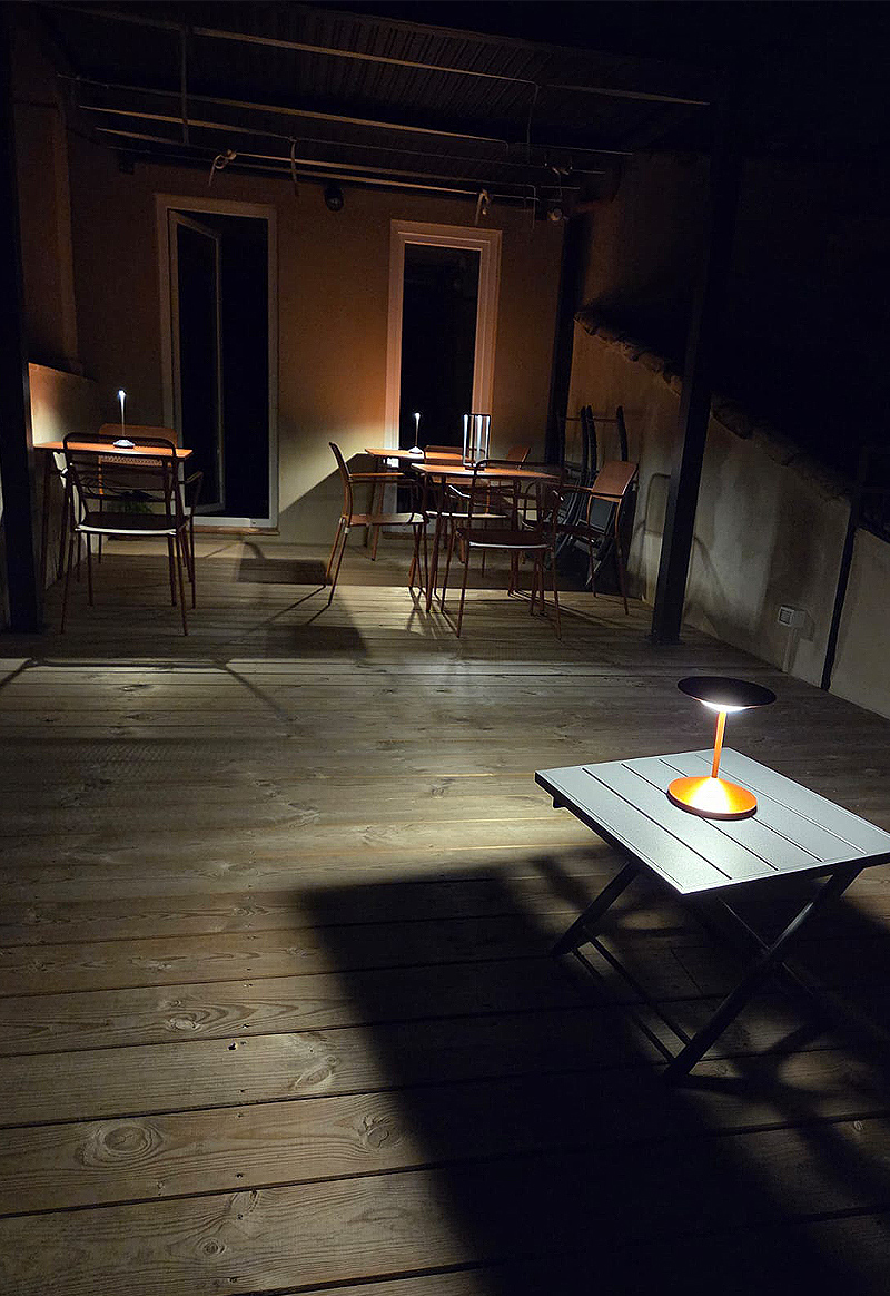 Tavolini illuminati sulla terrazza durante la sera